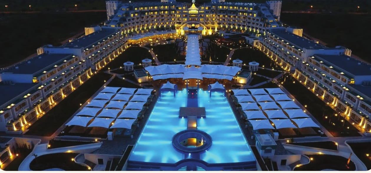 A five-star resort hotel in Northern Cyprus lit up at night around a long pool