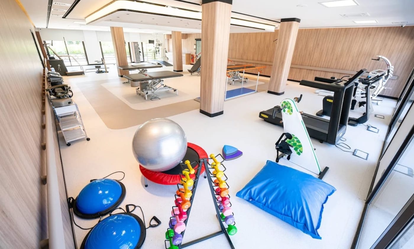 The daylit rehabilitation hall with treatment tables, balance equipment and exercise balls