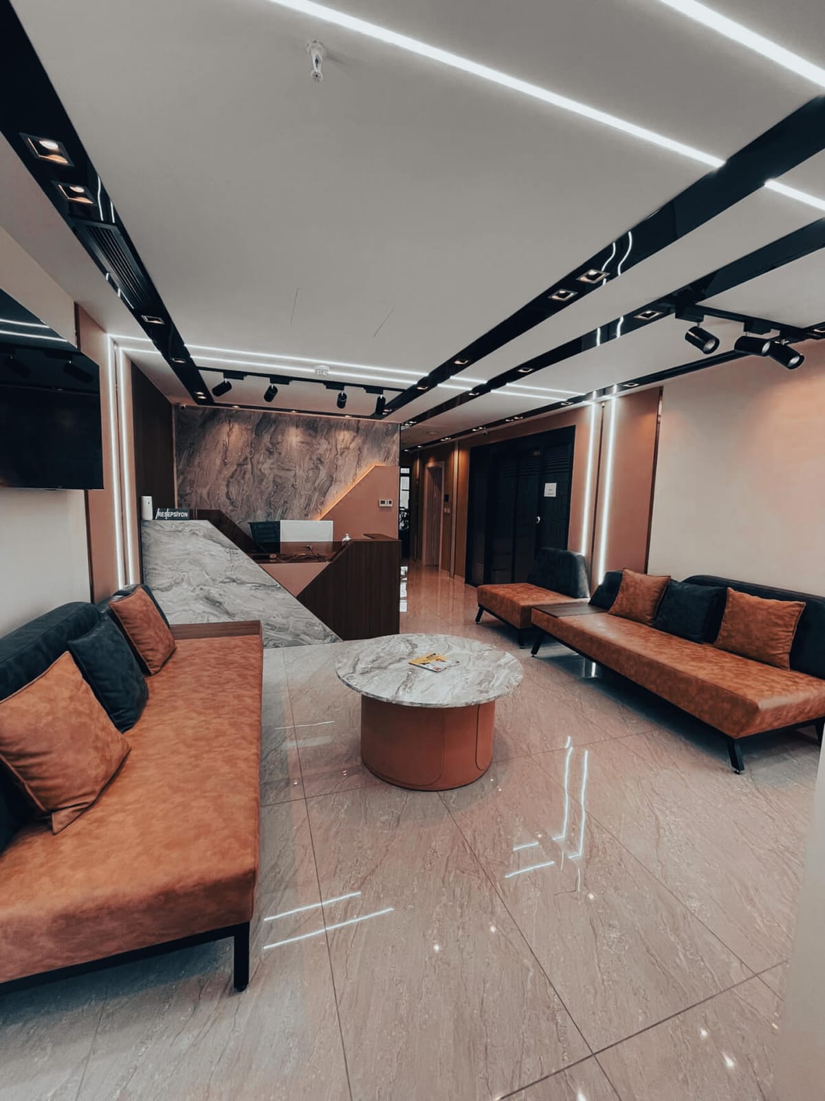 The patient lounge at Suave Clinic with sofas and a corridor to the treatment rooms