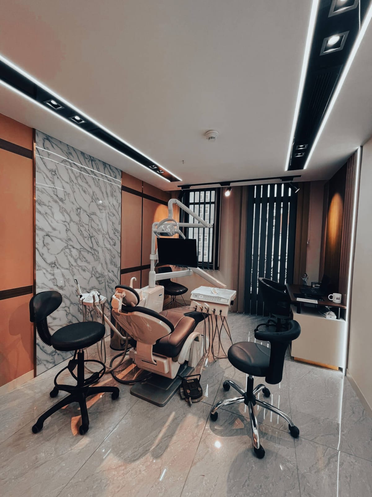 A treatment room at Suave Clinic in Istanbul with a dental chair, monitor and marble feature wall