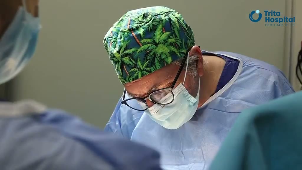 A surgeon at Trita Hospital operating, in surgical cap and mask